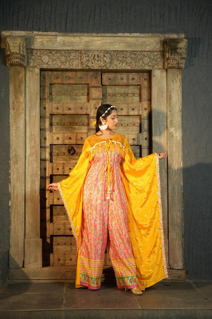 Model wearing Famameha yellow and pink luxury kaftan-style outfit with wide flowy sleeves, handcrafted boho-luxe fashion from India